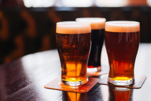 Glasses of light and dark beer on a pub background.